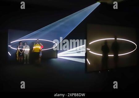 Besucher genießen „Solid Light“, eine immersive Kunstinstallation des Künstlers Anthony McCall, die derzeit im Tate Modern in London, Großbritannien, zu sehen ist. Die Ausstellung läuft bis zum 27. April 2025 Stockfoto