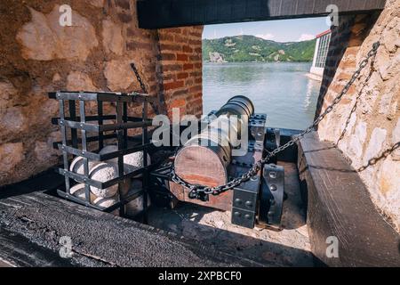 Eine alte Kanone bewacht eine alte Festung und zeigt die mittelalterliche Militärgeschichte vor dem Hintergrund von Steinmauern und blauem Himmel. Stockfoto