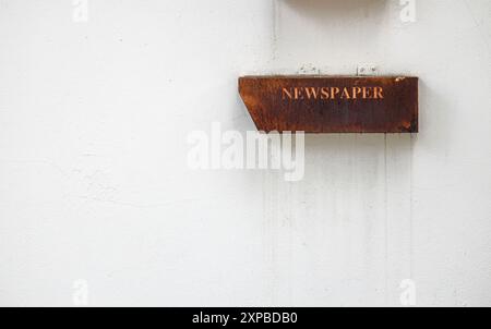 Alte Briefkasten oder Zeitungskiste aus Metall an der weißen Zementwand. Stockfoto