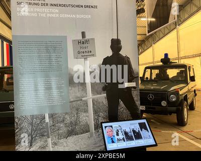 PRODUKTION - 02. August 2024, Rasdorf: Schautafeln, ein ehemaliges Patrouillenfahrzeug und eine digitale Mediastation sind in einer Sonderausstellung zur Geschichte des Bundesgrenzschutzes am Point Alpha Memorial zu sehen. Besucher können verschiedene Zeitzeugen auswählen, indem sie auf den Bildschirm tippen und ihnen dabei zuhören, wie sie über verschiedene Epochen des Bundesgrenzschutzes sprechen. Foto: Michael Bauer/dpa Stockfoto