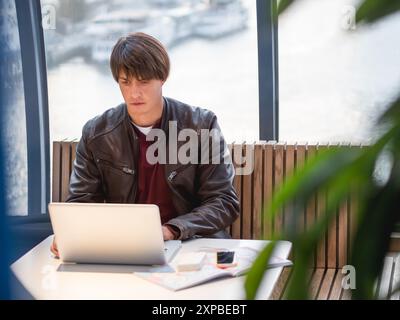 Geschäftsmann arbeitet mit Laptop- und Papierorganisator in einem Co-working Center zusammen. Arbeitsplatz für Freiberufler im Business Center. Stockfoto