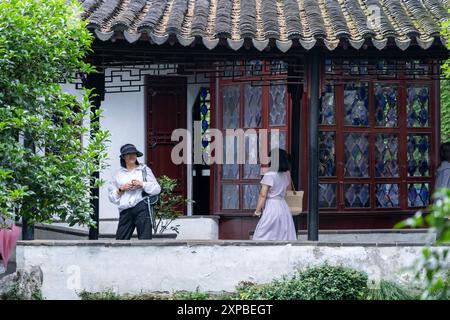 Suzhou, China - 11. Juni 2024 : zwei Frauen spazieren durch einen traditionellen chinesischen Garten in Suzhou. Stockfoto