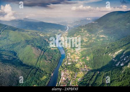 Aus der Vogelperspektive auf den Fluss Drina, der sich durch den Naturpark Tara schlängelt, grüne Berge und Wälder in Serbien Stockfoto