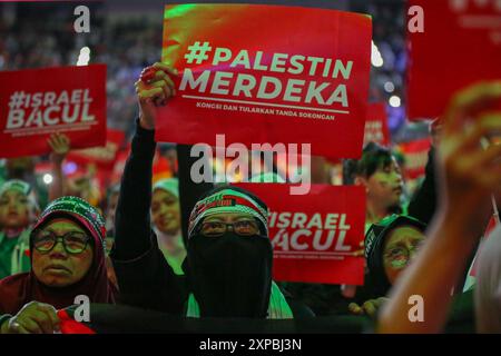 Kuala Lumpur, Malaysia. August 2024. Die Leute halten Plakate während der Befreiungskundgebung. Himpunan Pembebasan Palestin, genannt als Palestine Liberation Rally, ist eine malaysische Solidaritätsversammlung, um der Welt zu zeigen, dass Malaysia die Ermordung des Vorsitzenden des Politbüros der Hamas, Ismail Haniyeh, verurteilt und die Befreiung Palästinas weiterhin unterstützen wird. Mehr als zehntausend Menschen haben an der Veranstaltung teilgenommen, um ihre Unterstützung in der Axiata Arena zu zeigen. (Foto: Faris Hadziq/SOPA Images/SIPA USA) Credit: SIPA USA/Alamy Live News Stockfoto