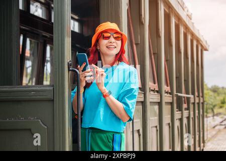 Touristin, die ein Smartphone benutzt, um ein Online-Ticket für die Retro-Zugfahrt in Mokra Gora, Serbien, zu kaufen Stockfoto