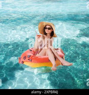 Poster. Zeitgenössische Kunstcollage. Frau mit Cocktail sitzt in süßem Donut wie auf dem Schwimmen, Poolring in Meereswellen genießt, entspannt. Stockfoto