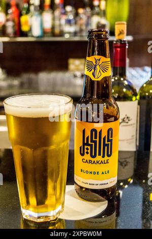 Eine Flasche und ein Glas Carakale Jordanisches Craft-Bier an der Bar, Holiday Inn Beach Hotel, Swemeh, Totes Meer, Jordanien, mit Flaschen Jordanischem Wein Stockfoto