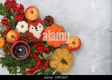 Warmes Stillleben im Herbst. Farbenfrohe Komposition mit dekorativen Kürbissen, vogelbeeren, Kerze, Blättern und Blumen. Tischdekoration Nahaufnahme Foto. Stockfoto
