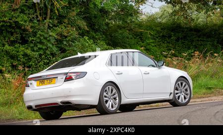 Whittlebury, Norhants, Großbritannien - 4. August 2024. 2011 weißes Saab 9-5 Auto, das auf einer britischen Landstraße fährt Stockfoto