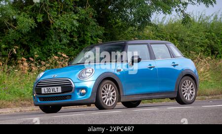 Whittlebury, Norhants, Großbritannien - 4. August 2024. 2015 blauer Mini Cooper Car, der auf einer britischen Landstraße fährt Stockfoto