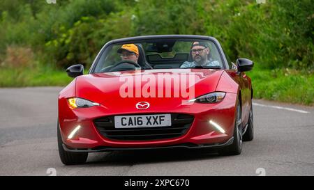 Whittlebury, Norhants, Großbritannien - 4. August 2024. 2016 rotes Mazda MX-5-Auto, das auf einer britischen Landstraße fährt Stockfoto