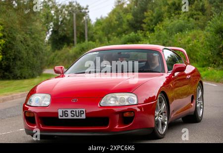 Whittlebury, Norhants, Großbritannien - 4. August 2024. 1993 roter Toyota Supra Oldtimer, der auf einer britischen Landstraße fährt Stockfoto