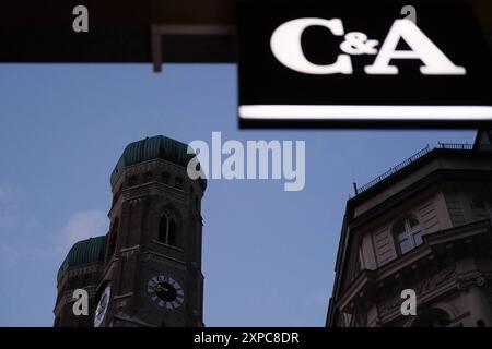 Frauenkirche gegenüber C&A Blick auf die beiden Türme der Frauenkirche Münchner Innenstadt. Im Vordergrund leuchtet das C&A Schild der Innenstadt-Fili Stockfoto