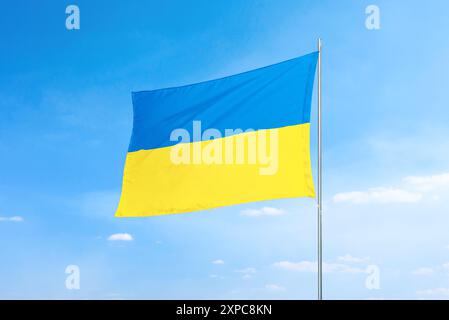 Ukrainische Flagge, die stolz auf Glauben und Nationalstolz steht. Die lebendigen Farben und die flatternde Bewegung der Flagge betonen den Geist und die Widerstandsfähigkeit Stockfoto