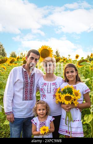 Familie auf dem Sonnenblumenfeld mit gesticktem Hemd. Selektiver Fokus. Natur. Stockfoto