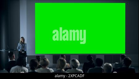 Firmenveranstaltung: Kaukasische weibliche Tech-CEO präsentiert Kollegen im Konferenzraum des Startup Office eine Präsentation auf dem Green Screen Chromakey Projector Display. Frau, Die Über Geschäftsziele Spricht. Stockfoto