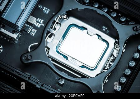 Ein Computerprozessor wird sorgfältig in seinem Sockel auf der Hauptplatine positioniert und zeigt das komplizierte Design und die Anschlüsse. Stockfoto