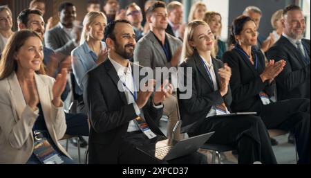 Viele Smart-Tech-Mitarbeiter applaudieren in der Konferenzhalle während einer Motivational Keynote-Präsentation von innovativem Unternehmen. Business Technology Summit Auditorium Saal voller Unternehmensdelegierter. Stockfoto