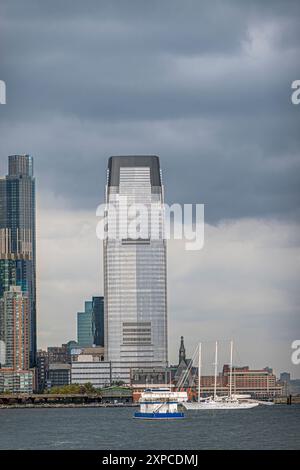 New York, NY, USA - 4. August 2023: New Jersey City zweithöchstes Gebäude an der Hudson Street 30 unter dunklen Wolken. Kleine Boote auf dem Hudson River Stockfoto