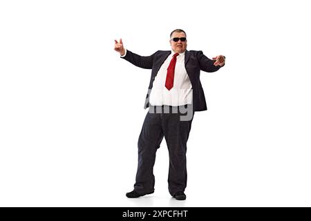 Geschäftsmann mit überwiegendem Körper, trägt formelle Kleidung, schwarzen Anzug, weißes Hemd und Sonnenbrille, die isoliert auf weißem Hintergrund tanzt. Stockfoto