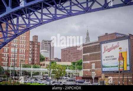 Die Landschaft von Cleveland unter der Main Avenue Bridge (Cleveland Memorial Shoreway) mit Bierwerbung, Bürogebäuden und Wolkenkratzern Stockfoto