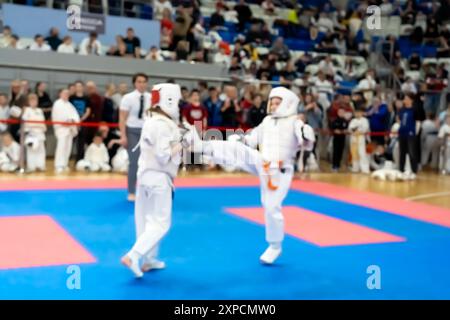 Verschwommenes, unscharfes Bild mit zwei Karate-Praktizierenden auf einer Tatami-Matte. Karatespieler, die während des Spiels antreten Stockfoto