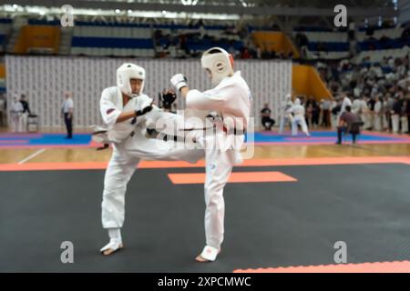 Verschwommenes, unscharfes Bild mit zwei Karate-Praktizierenden auf einer Tatami-Matte. Karatespieler, die während des Spiels antreten Stockfoto