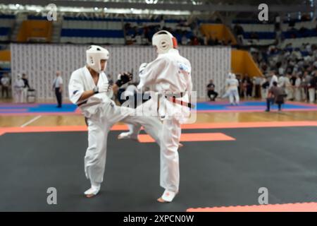 Verschwommenes, unscharfes Bild mit zwei Karate-Praktizierenden auf einer Tatami-Matte. Karatespieler, die während des Spiels antreten Stockfoto