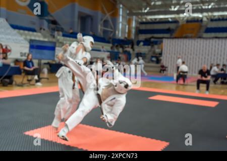 Verschwommenes, unscharfes Bild mit zwei Karate-Praktizierenden auf einer Tatami-Matte. Karatespieler, die während des Spiels antreten Stockfoto