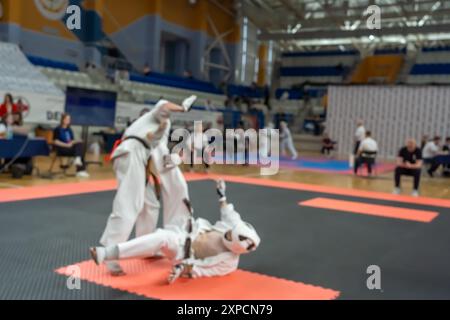 Verschwommenes, unscharfes Bild mit zwei Karate-Praktizierenden auf einer Tatami-Matte. Karatespieler, die während des Spiels antreten Stockfoto