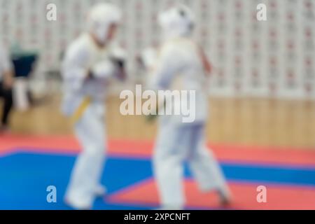 Verschwommenes, unscharfes Bild mit zwei Karate-Praktizierenden auf einer Tatami-Matte. Karatespieler, die während des Spiels antreten Stockfoto