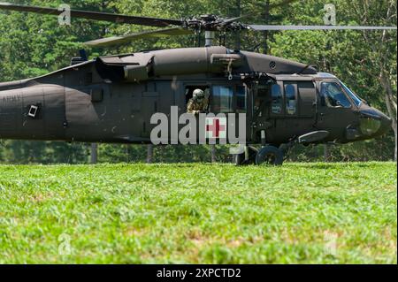 Medizinisches Team auf einem Sikorsky HH-60M MEDEVAC Black Hawk Helicopter landet, um einem verletzten Fallschirmjäger während des Leapfest 2024 in der Dropzone zu helfen. Leapfest Stockfoto