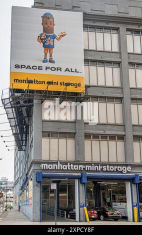 New York, NY, USA - 3. August 2023: Manhattan Mini-Lagerplatz mit großer Plakatwand und offener Garage an der Ecke W 44th Street und 12th Ave Stockfoto