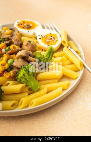 Leckeres Frühstück, Pasta mit gebratenen Pilzen und Brokkoli, grüne Erbsen und Mais, frischer Salat mit Radieschen mit Samen, Blick von oben Stockfoto