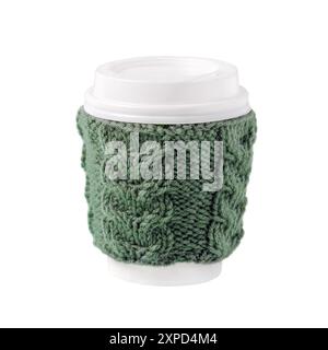 Tasse für Kaffee zum Mitnehmen mit gestrickter grüner Abdeckung auf weißem Hintergrund. Konzept von Kaffee zum Mitnehmen, Wandern, energiegeladenes Leben Stockfoto