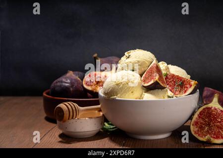 Leckeres Feigeneis, aromatisches und cremiges Fruchtsorbet-Dessert mit herbstlich würzigem Geschmack, in portionierter Schüssel, auf hölzernem Hintergrund mit Whol Stockfoto