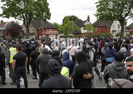 Bordesely Green, Birmingham 5. August 2024 - Hunderte von Menschen kamen heraus, um lokale Geschäfte und eine Moschee (Village Islamic Centre) zu schützen, nachdem Gerüchte über Mitglieder der EDL und andere Demonstranten in die Gegend kamen. Die Geschäfte wurden geschlossen und ein lokales Krankenhaus schickte das Personal nach Hause, da zu erwarten war, dass Gewalt bedroht war. Aufgrund der Reaktion der Komunionen kamen jedoch keine Patrioten an und die friedlichen Proteste setzten sich durch. ENDE - Guthaben: Stop Press Media/Alamy Live News Stockfoto