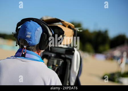 Versailles, Frankreich. August 2024. Olympia, Paris 2024, Reitsport, Springreiten, Vorwettbewerb, Einzelperson, Qualifikation, Ein Kameramann mit den Logos von Olympic Broadcasting Services (OBS) und die Olympischen Ringe filmen die Action. Quelle: Rolf Vennenbernd/dpa/Alamy Live News Stockfoto