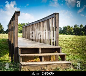 Holzsteg über flaches, grasgesäumtes Schweben Stockfoto