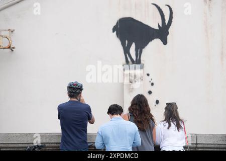 London, Großbritannien. August 2024. Die Leute fotografieren das neueste Kunstwerk des Street Artist Banksy, das eine Bergziege zeigt, die auf der Säule eines Gebäudes thront und Felsen an der Kew Bridge herunterfallen. Quelle: Justin Ng/Alamy Live News. Stockfoto