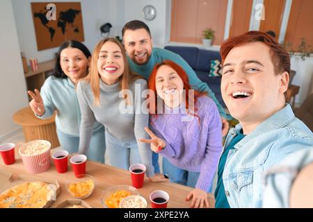 Junger Mann mit Freunden, der Selfie auf der Heimfeier macht, Nahaufnahme Stockfoto