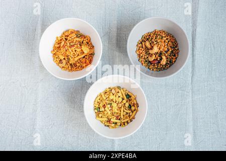 Indische Snacks in Schüsseln auf grauer Tischdecke. Draufsicht. Stockfoto