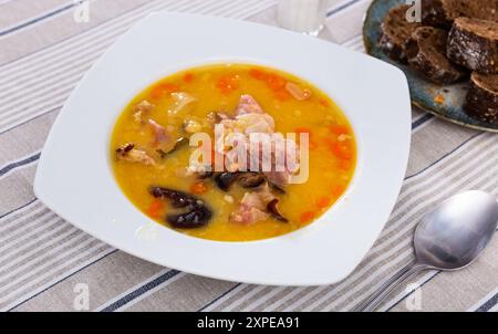 Heiße Erbsensuppe mit geräuchertem Fleisch und Gemüse Stockfoto