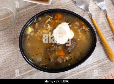 Suppe mit verschiedenen Pilzen, Gemüse und Schweinefleisch Stockfoto