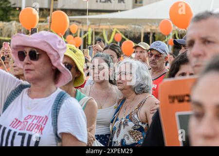 Tel Aviv, Israel. August 2024. Israelis reißen zusammen, während sie orangene Ballons halten, an Ariel Bibas 5. Geburtstag auf dem Geiselplatz. Die Israelis versammelten sich auf dem Geiselplatz und ließen orangene Ballons aus Anlass des fünften Geburtstags der israelischen Geisel Ariel Bibas frei, die am 7. Oktober entführt und 304 Tage in der Hamas-Gefangenschaft in Gaza festgehalten wurde. Quelle: SOPA Images Limited/Alamy Live News Stockfoto