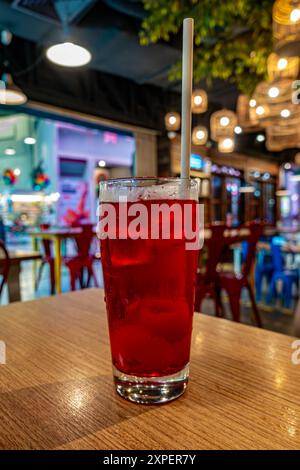 Ein Glas Litschi-Saft mit Trinkstroh auf einem Tisch in einem Restaurant. Stockfoto