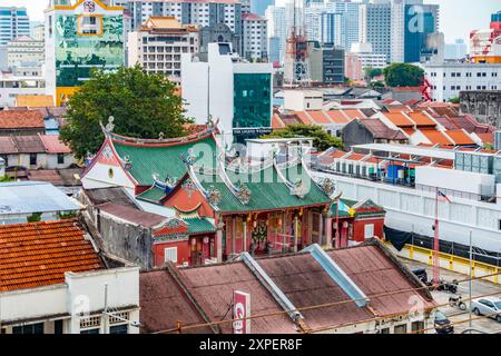 Ein chinesischer Tempel mitten in George Town, Penang, Malaysia, umgeben von einer Mischung aus alter und moderner Architektur. Stockfoto