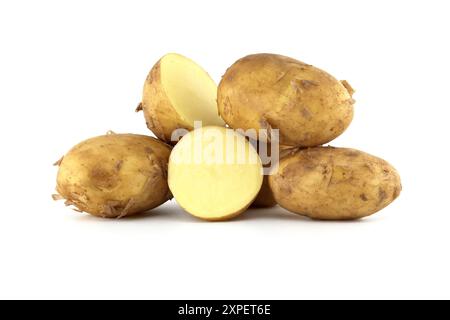 Gruppe frischer Frühkartoffeln mit hellbrauner Haut und dunkelbraunen Flecken auf weißem Hintergrund, eine Kartoffel in Teilung zeigt ihr Gelb Stockfoto