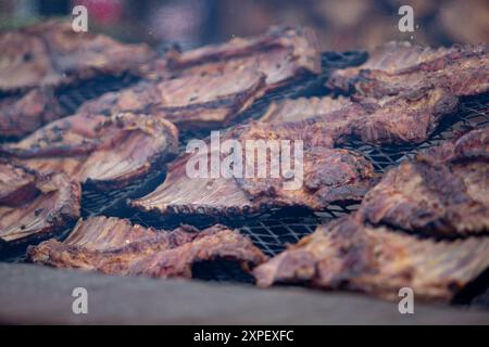 Blick auf eine große Grillfläche voller Rindfleischrippchen. Stockfoto