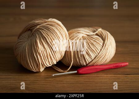 Zwei Knäuel Garn zum Stricken und Haken auf dem Tisch Stockfoto